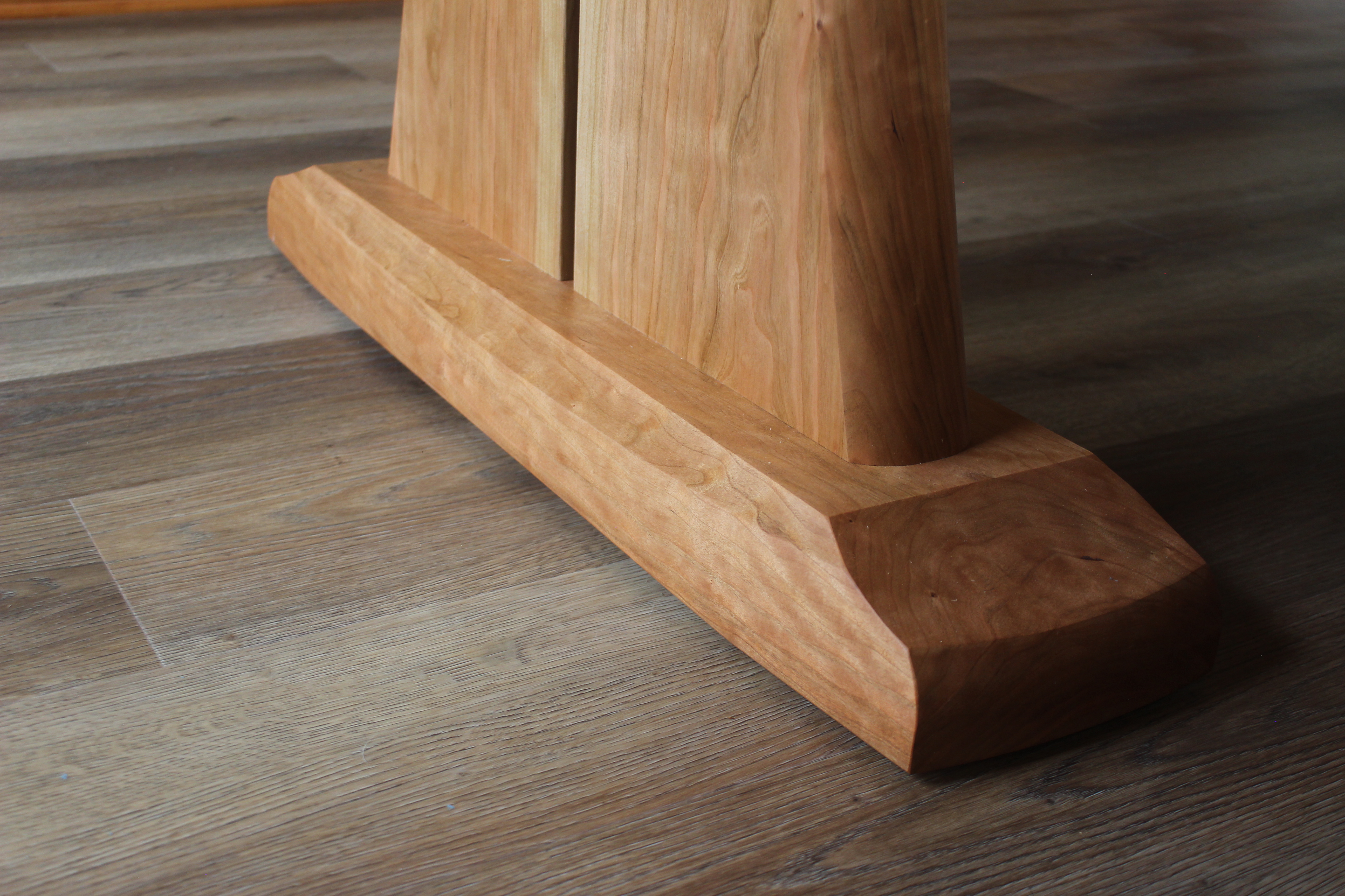 Close-up view of a wooden furniture base, showcasing its smooth, polished surface and unique grain patterns.